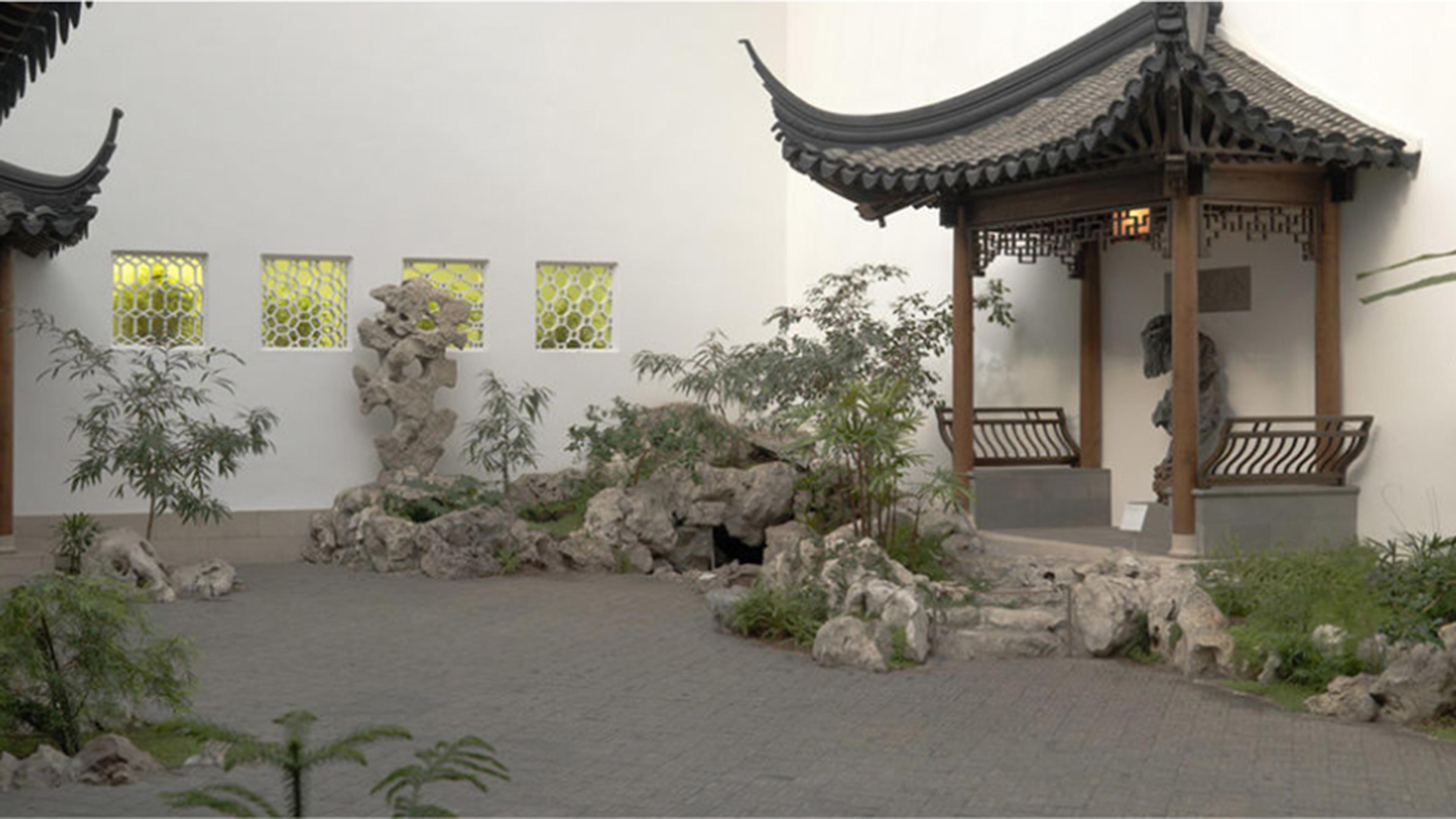 View of the Astor Court pavilion surrounded by low plants and stones.