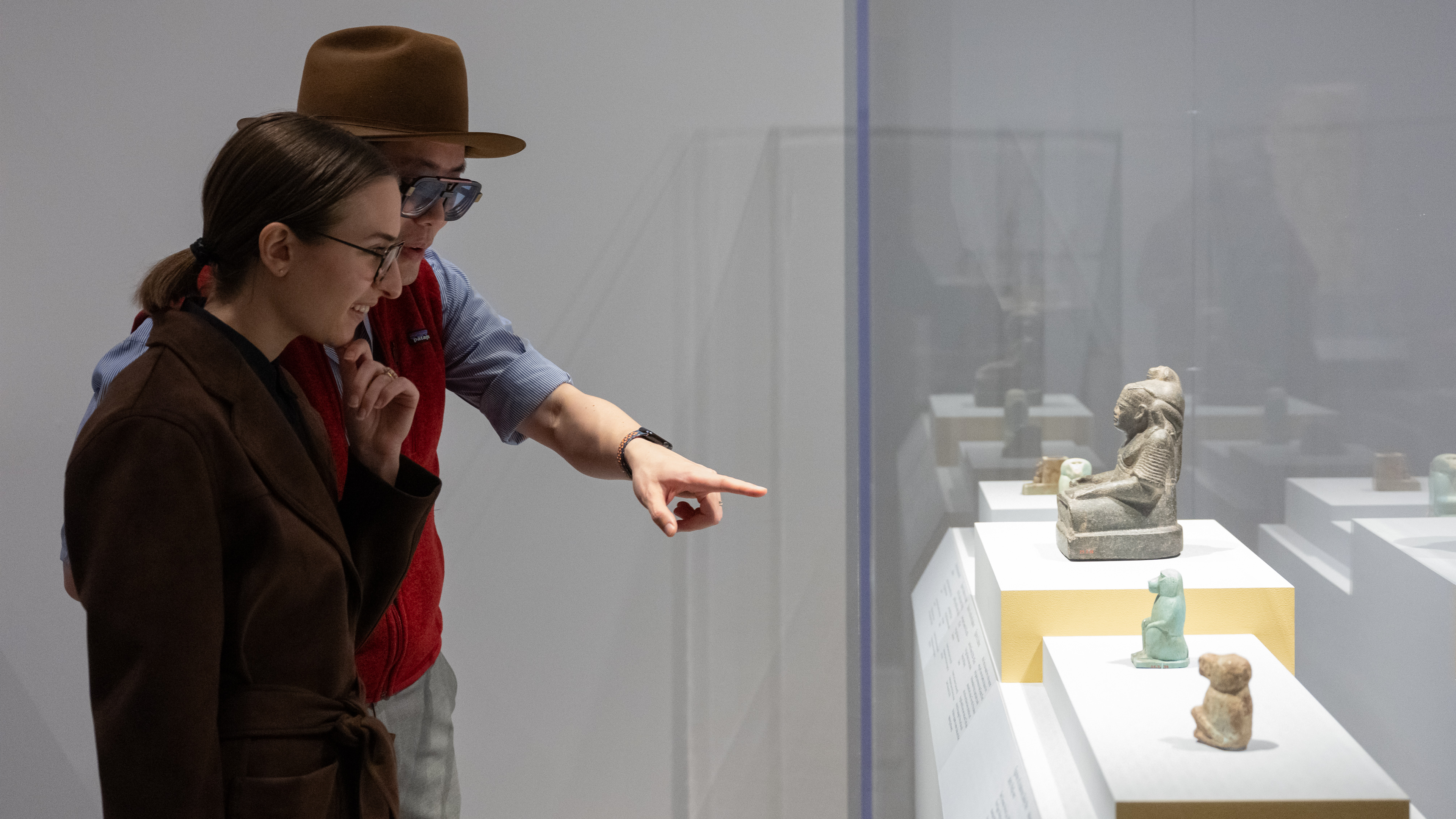 Two people pointing at sculptures.